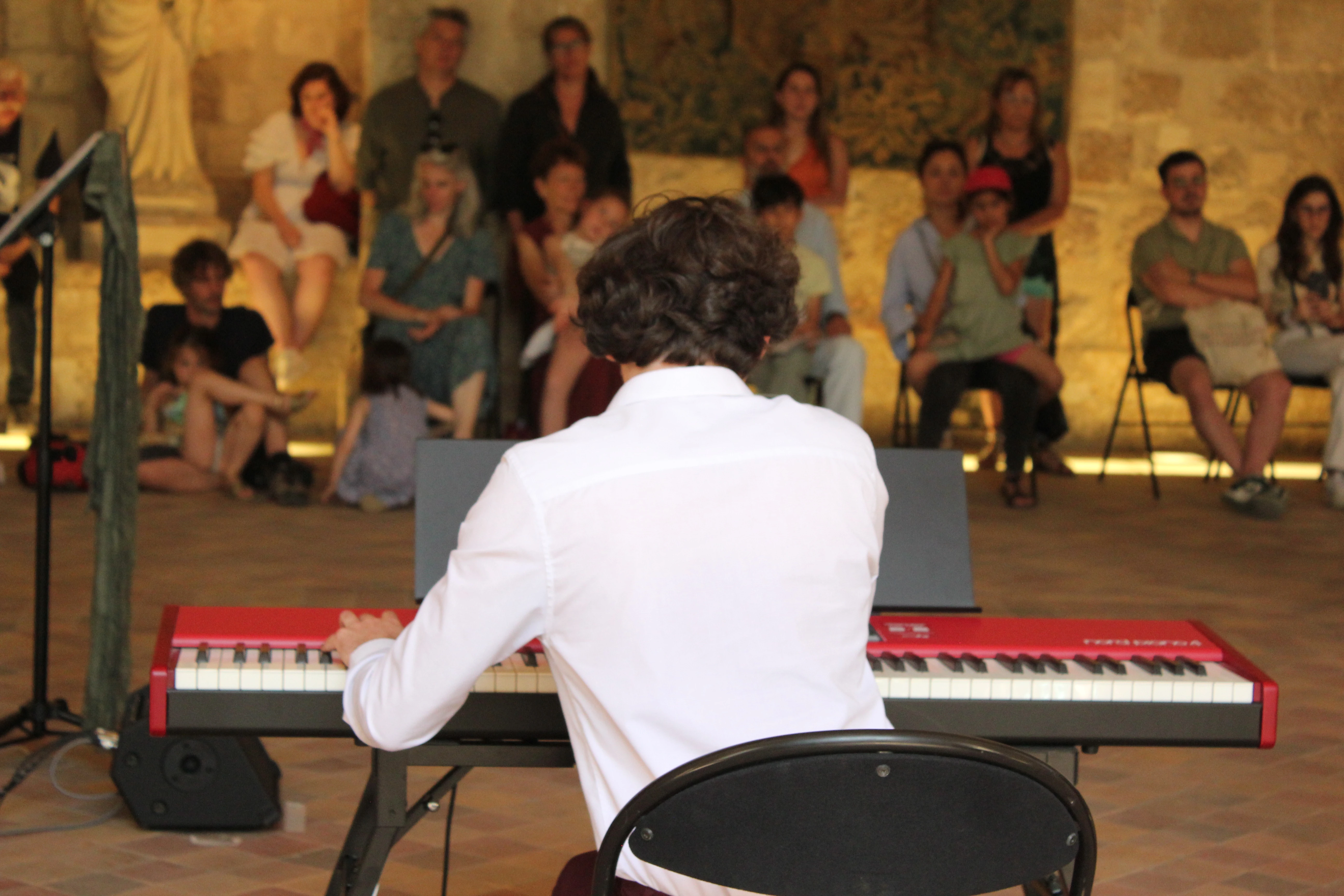Anthony Mounier au piano de dos, lors d'un concert à l'abbaye de Royaumont